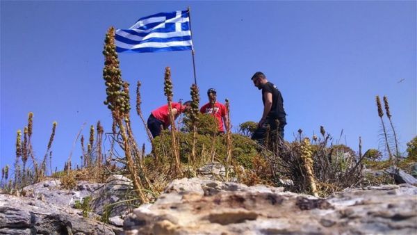 Φωτογραφίες με νεαρούς να υψώνουν ελληνική σημαία στη νησίδα Ανθρωποφάγοι